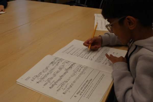 A child working through a music theory book