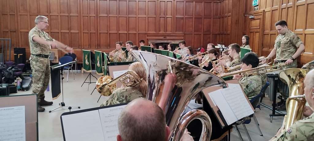 A photo of The Band of The Royal Yorkshire Regiment performing with a conductor